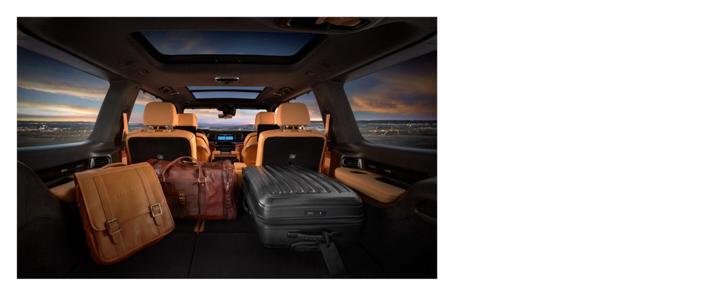 The cargo area of the 2023 Grand Wagoneer with the second and third rows folded and several suitcases in the hold.